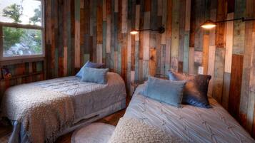 Een kamer met twee bedden, houten wanden en een raam.