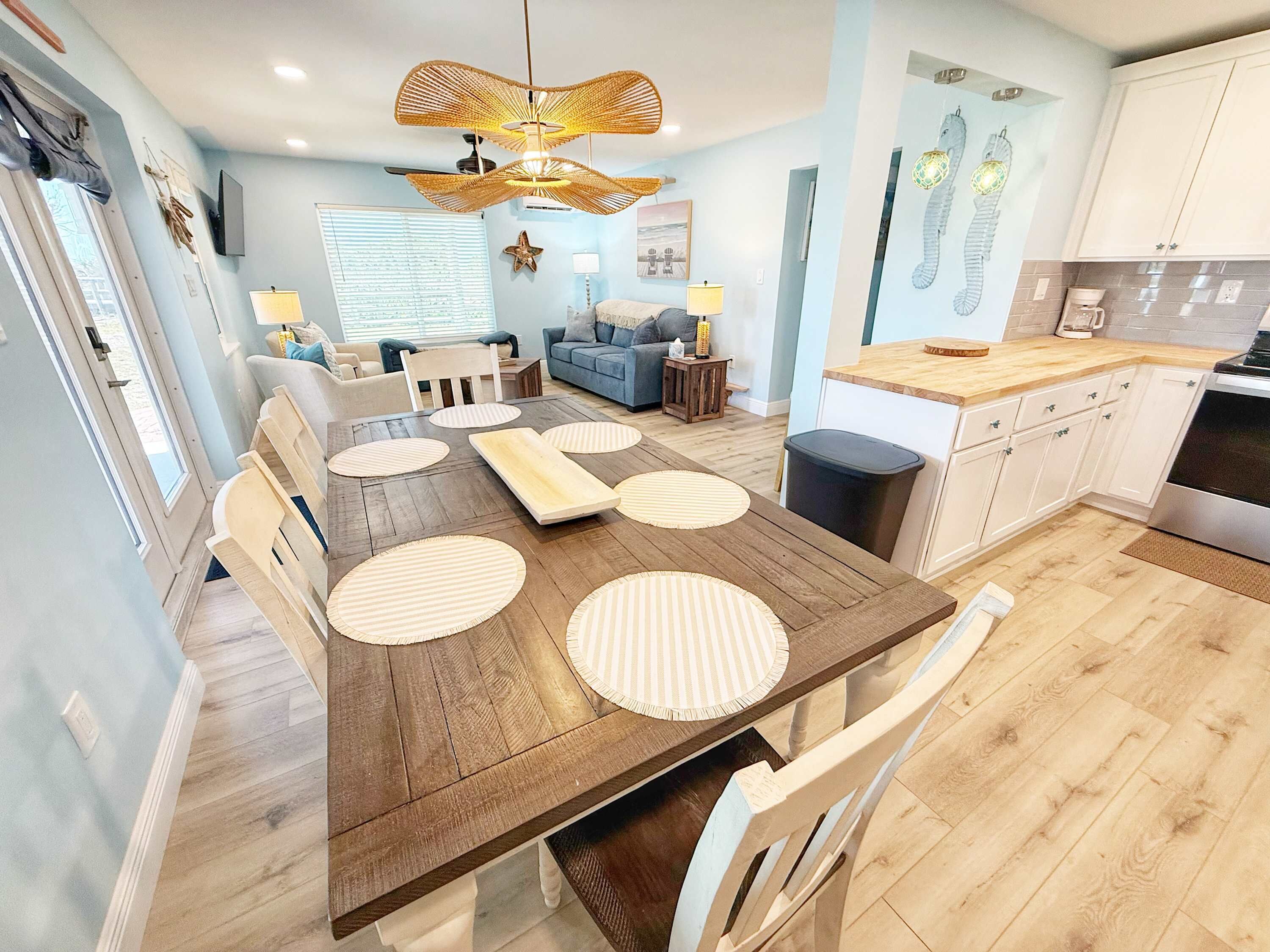 Une cuisine moderne avec une table en bois, des armoires blanches et un grand îlot central.