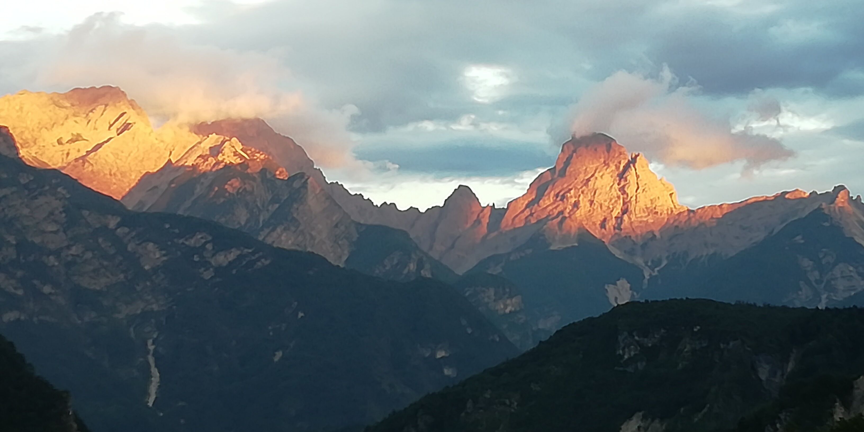 Een berglandschap met ruige toppen en een bewolkte lucht.