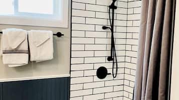 Un baño con bañera, ducha y ventana.