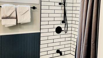 Un baño con bañera, ducha y ventana.