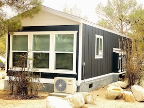 A single-story building with a dark exterior, white trim, and a small porch area.