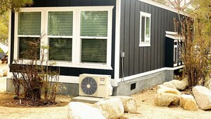 A single-story building with a dark exterior, white trim, and a small porch area.