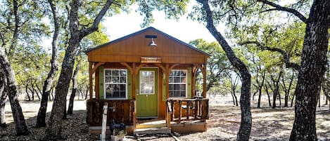 A small wooden cabin labeled 'CARRIAGE HOUSE' surrounded by trees.