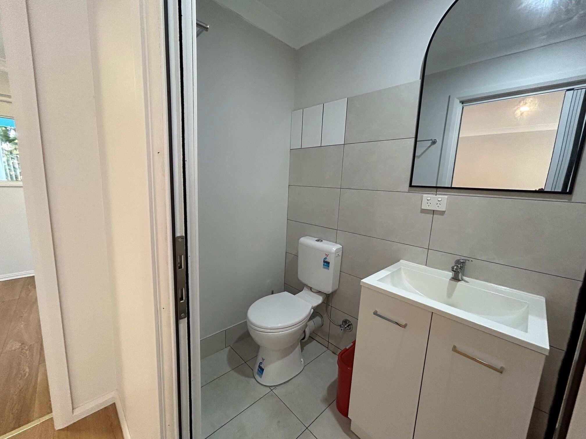 Ein Badezimmer mit Toilette, Waschbecken und Spiegel.