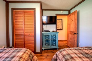 A bedroom with two beds, a blue cabinet, and wooden doors. - Cozy Lake Cabin with Hot-Tub in Topton, North Carolina (Topton)