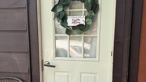 A white door with a wreath and a sign that reads 'Welcome to the Cozy Little Hideaway.' - Cozy Portage Lakes Hideaway (Akron)