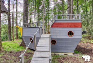 A wooden playhouse with a staircase, two hexagonal windows, and a red roof. - Fantastic Cabin Nestled Amidst Trees and Hot-tub Provided in Sevierville, Tennessee (Sevierville)