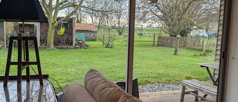 Una habitación con un amplio ventanal corredizo que da a un patio trasero.