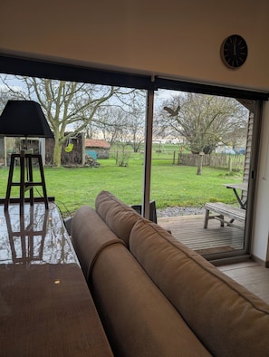 Ein Zimmer mit einer großen Schiebeglastür, die zu einem Garten führt.