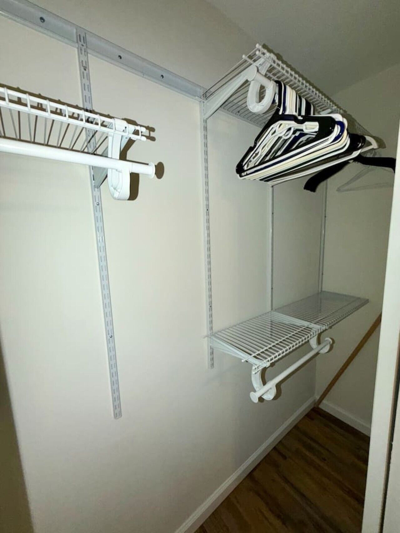 Un placard de rangement avec des étagères en métal et un espace pour suspendre les vêtements.