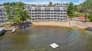 Un hotel a più piani con piscina, molo e sedie a sdraio.