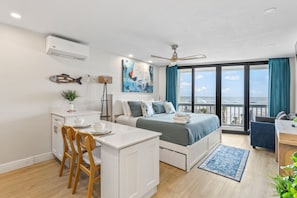 Ein modernes Schlafzimmer mit Bett, Schreibtisch und Balkon mit Blick.