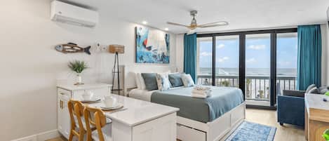 Un dormitorio moderno con cama, escritorio y balcón con vistas.