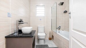 A bathroom with a sink, toilet, and bathtub.