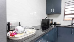 A modern kitchen with dark cabinets, a countertop, and a window.