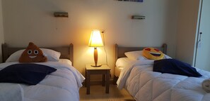 A hotel room with two beds, a bedside table with a lamp, and two wall-mounted air conditioning units. - 2BR Family Apartment in Gouvia – Apt 2 (Kontokali)