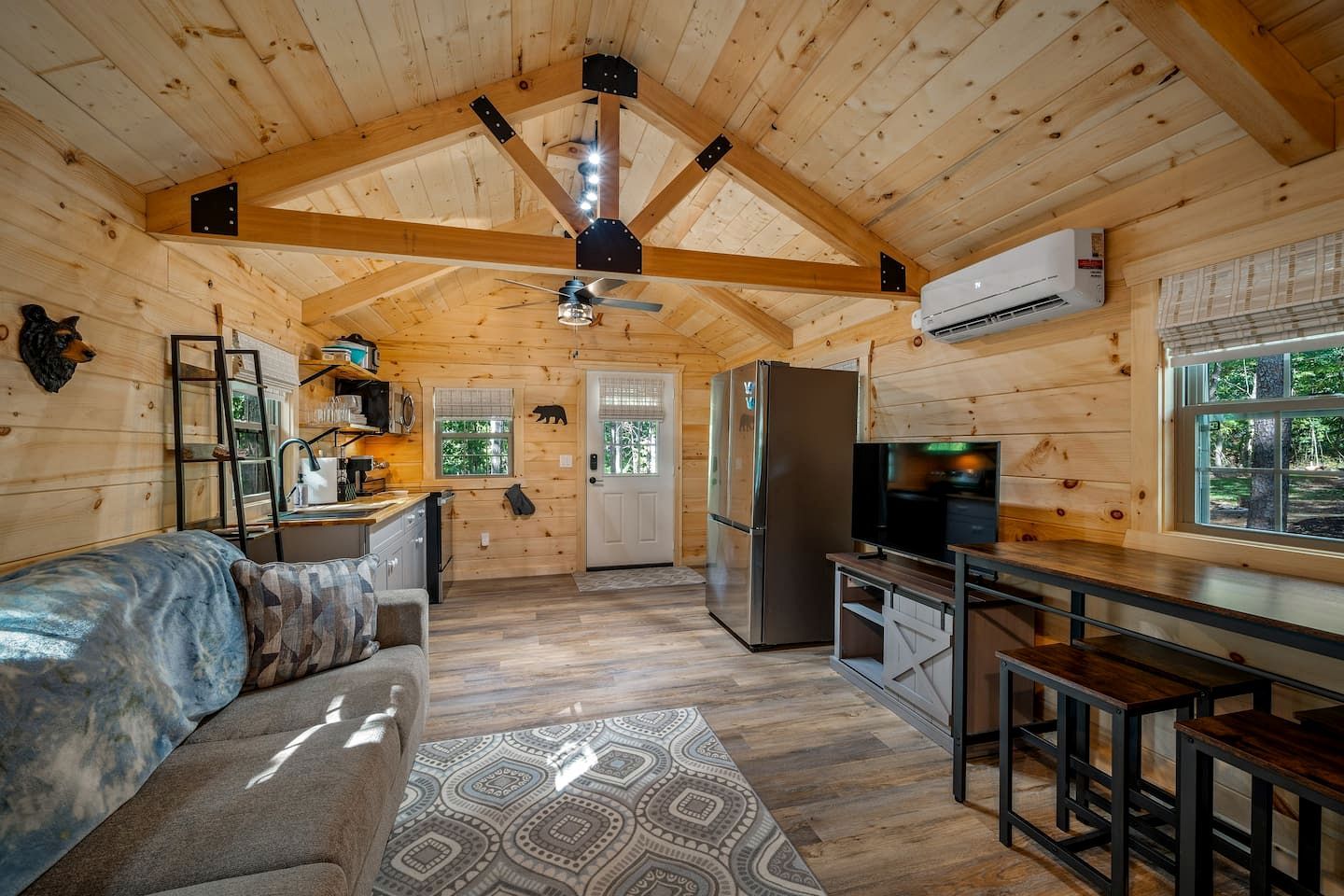 L’intérieur d’une cabane en rondins comprend une cuisine, un coin repas et un salon confortable.