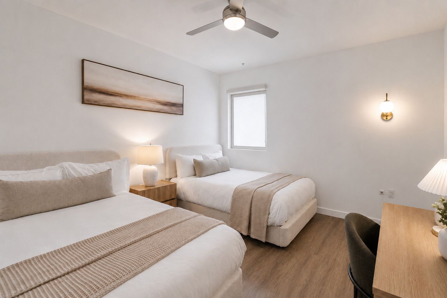 Une chambre d’hôtel avec deux lits, un ventilateur de plafond, une fenêtre et une table de chevet avec une lampe.