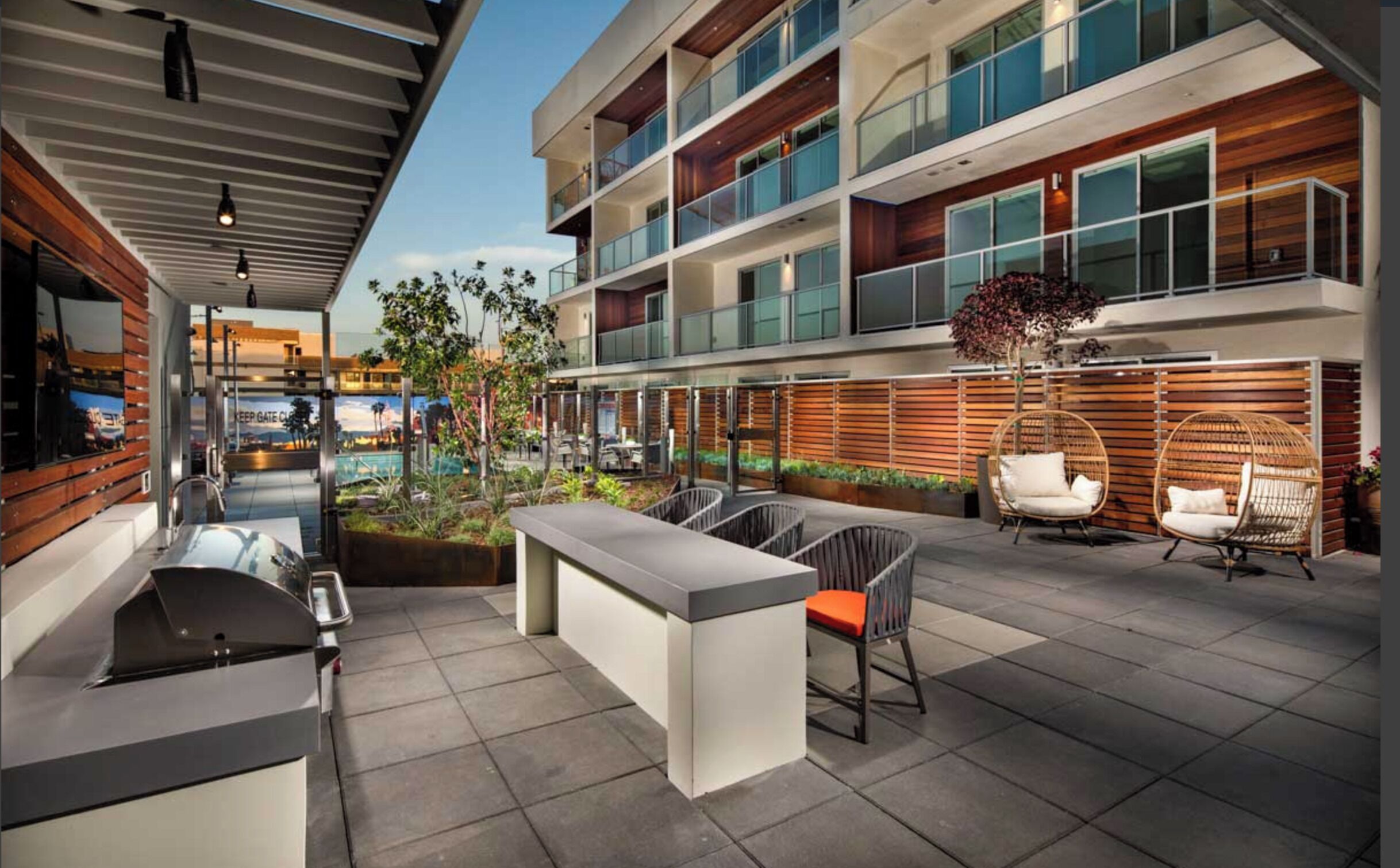 A modern outdoor area with a pool, seating, and a bar.