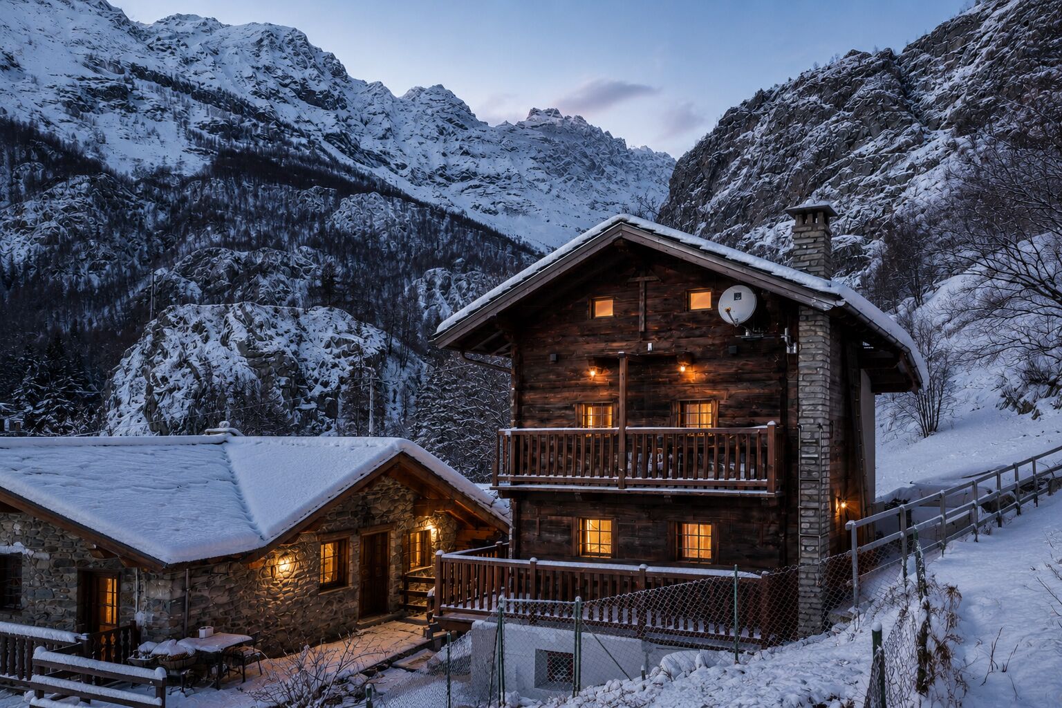 A log cabin with a balcony, stone walls, and a snow-covered mountain backdrop.