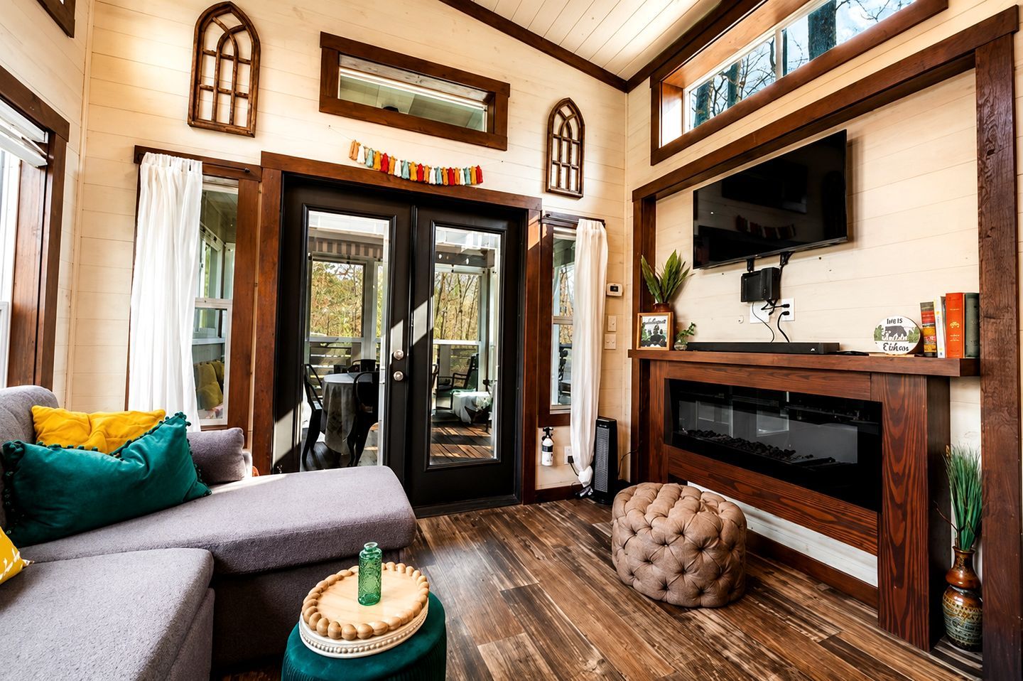 Een gezellige woonkamer met een open haard, een televisie en een eethoek met een tafel en stoelen.
