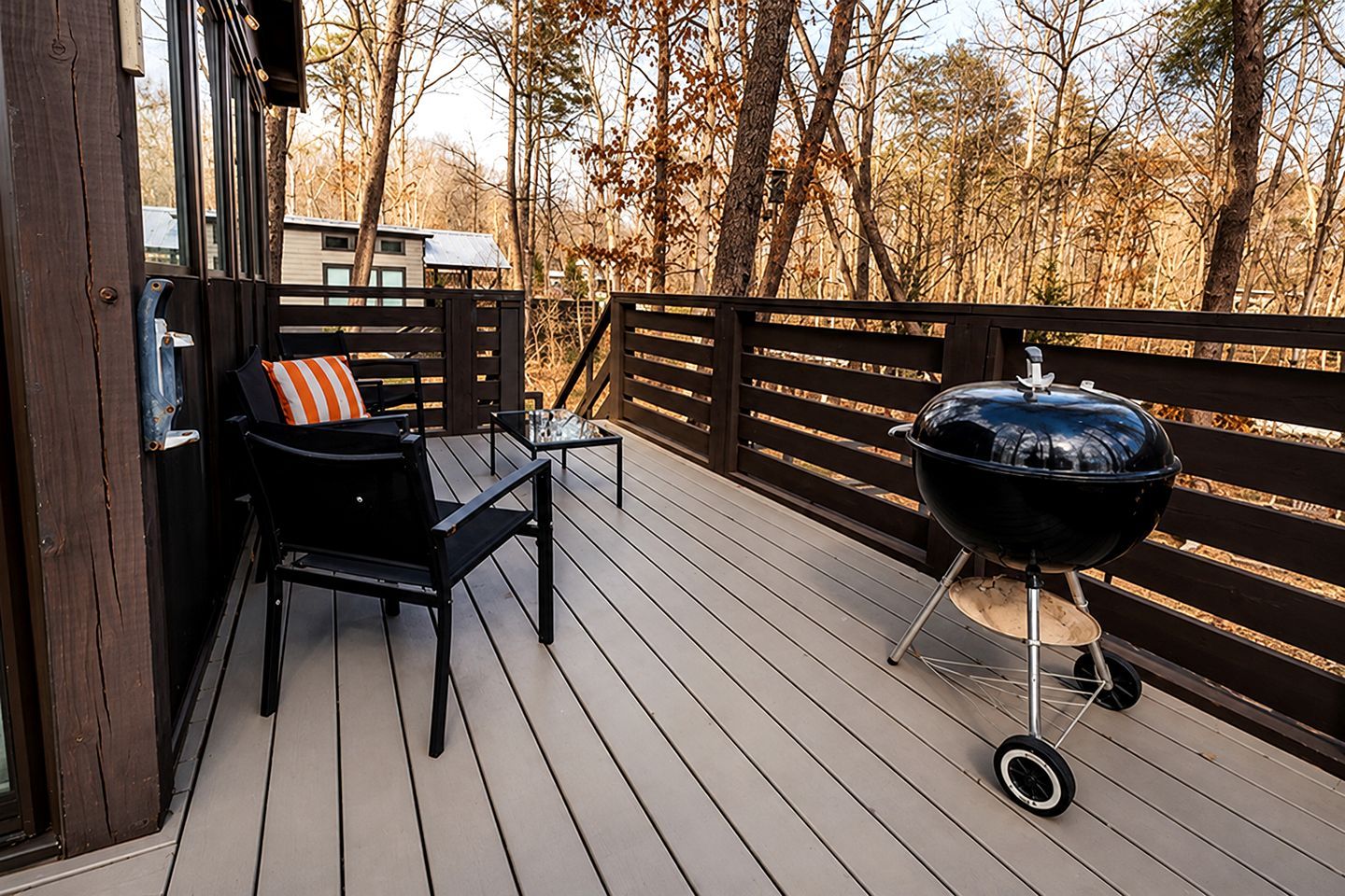 A deck with a grill and outdoor furniture.