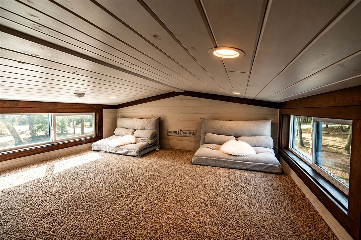 Un dormitorio con dos camas, techo de madera y suelo alfombrado.
