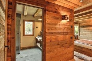 Ein Holzblockhaus-Innenraum mit Bad, Bett und Fenster.