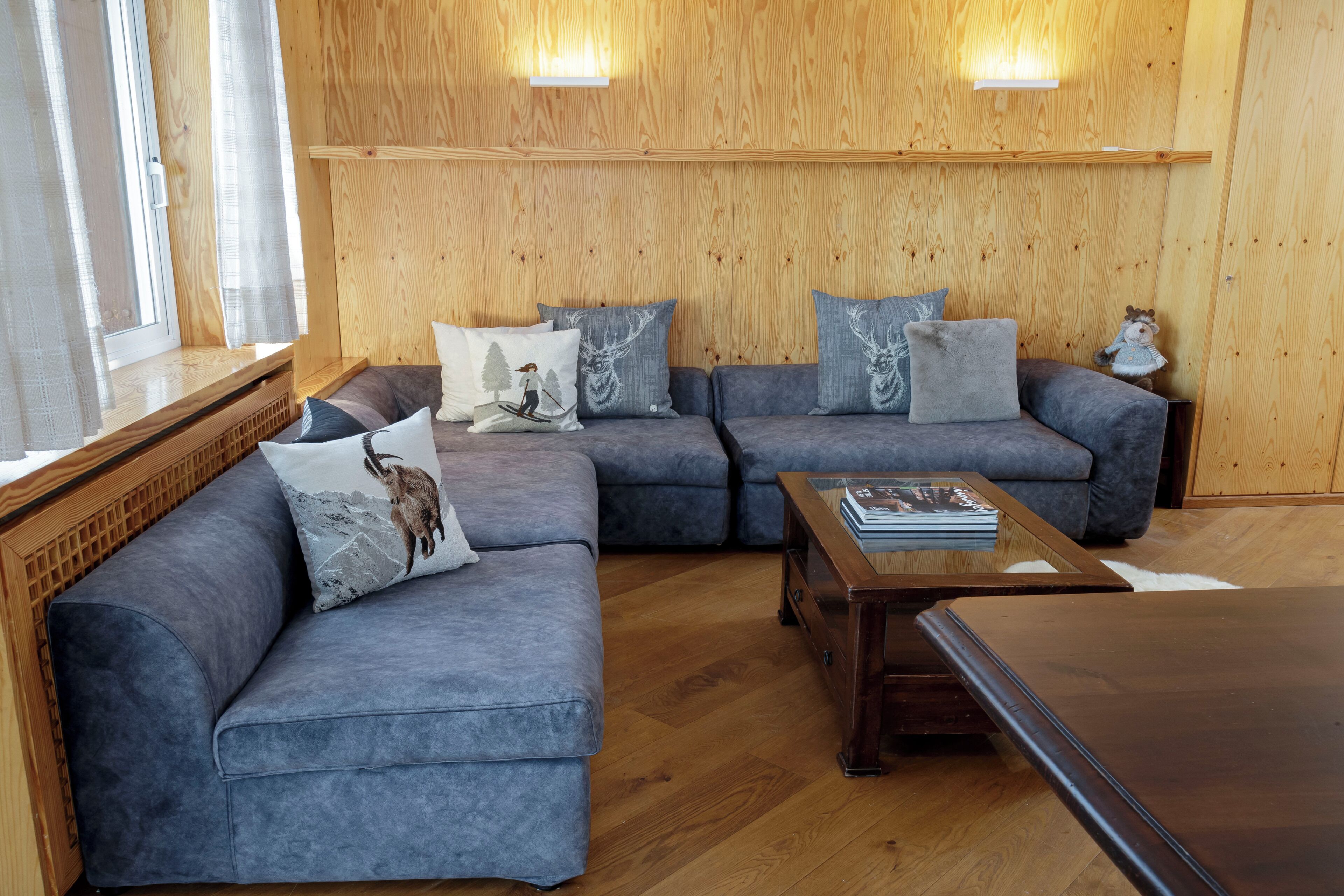 Una sala de estar moderna con un sofá modular, una mesa de centro y paneles de madera.