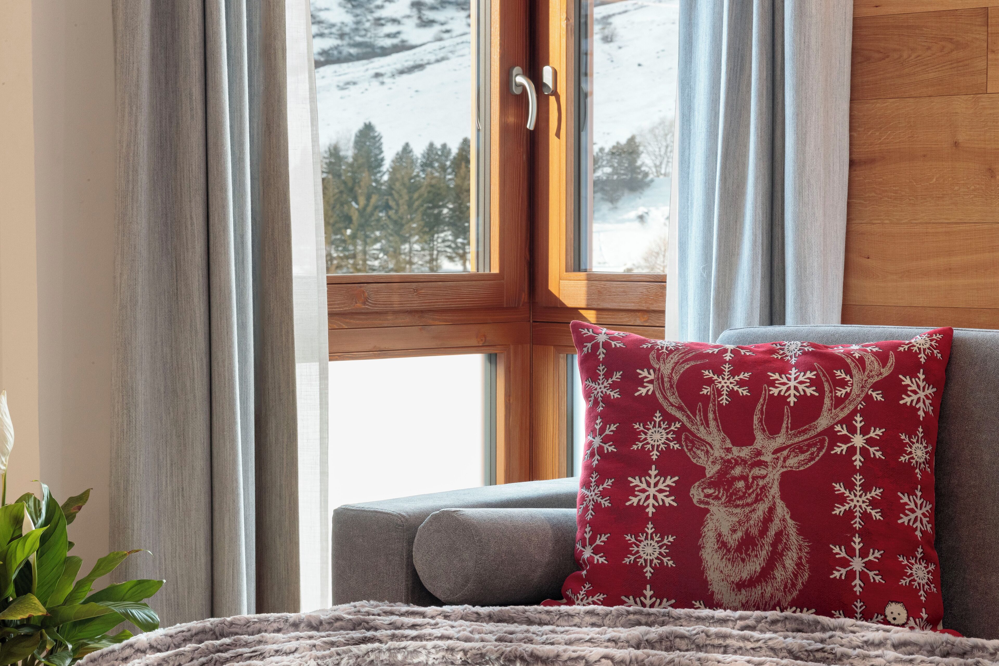 A cozy room with a window, a sofa, and a decorative pillow.
