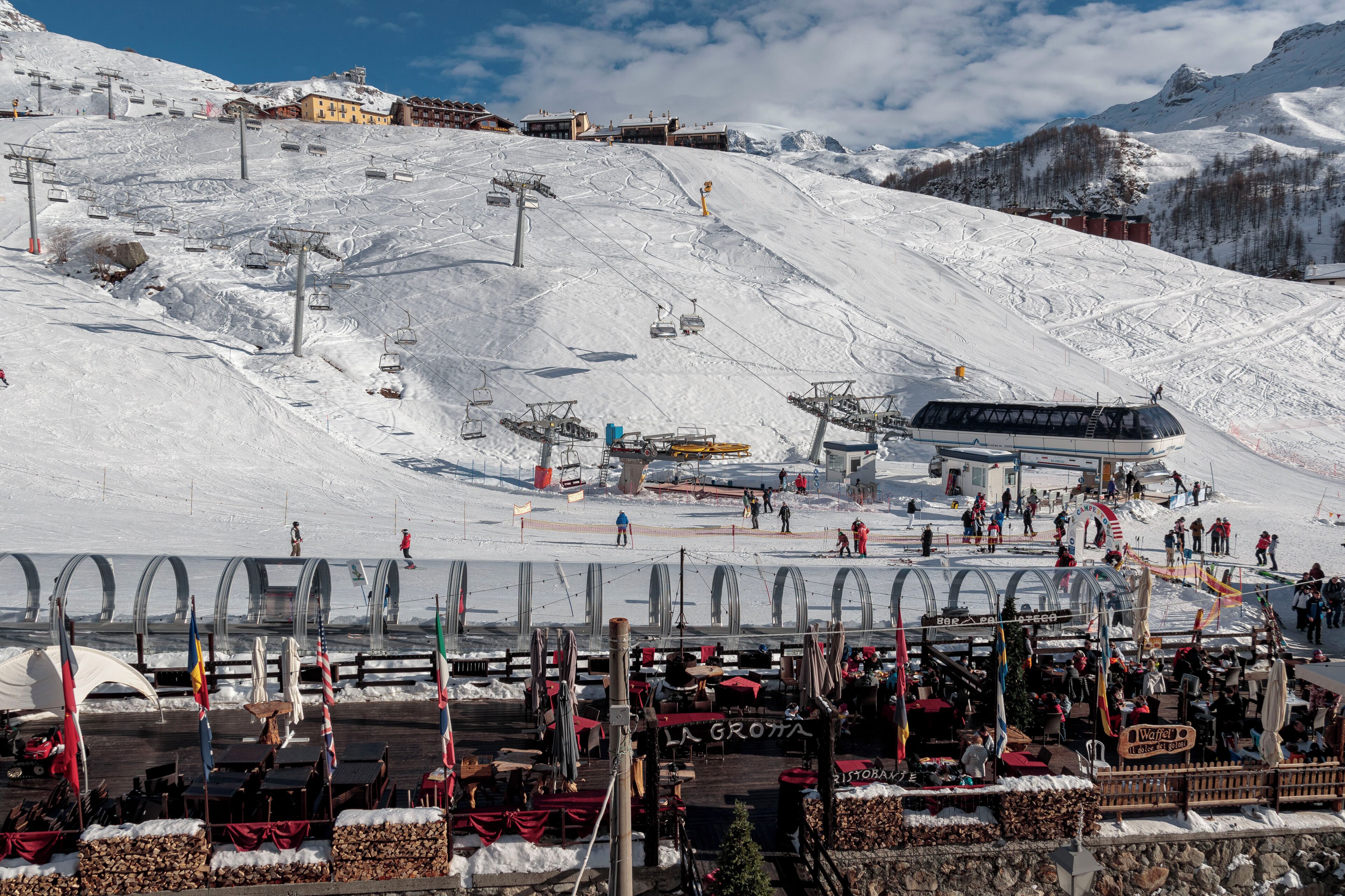 Ein Skigebiet mit Seilbahn, Restaurant und Bergblick.