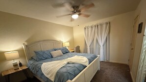 A bedroom with a bed, a nightstand, a lamp, a ceiling fan, and a window with curtains. - Fantastic cabin retreat for 6 with 2 bathrooms and AC in cozy Heber-Overgaard (Heber-Overgaard)