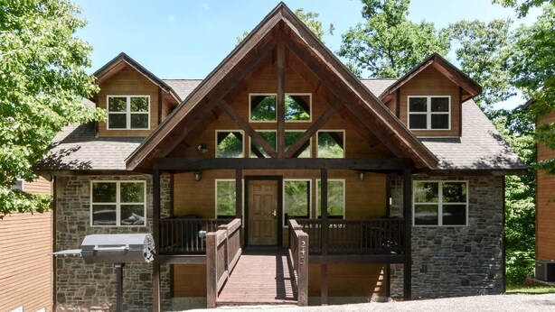 A lodge with a stone facade, wooden balconies, and a covered entrance. - Spacious Cabin with Indoor and Outdoor Swimming Pool in Branson, Missouri (Branson)