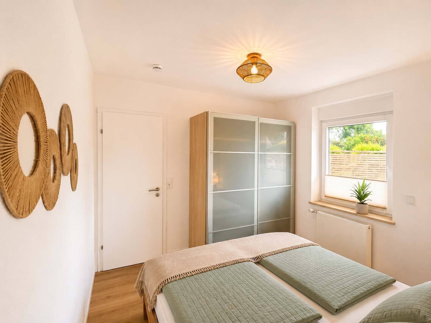 Un dormitorio con cama, armario, ventana con vistas y decoración en la pared.