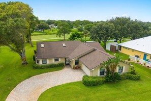 A two-story house with a paved driveway and a well-maintained lawn.