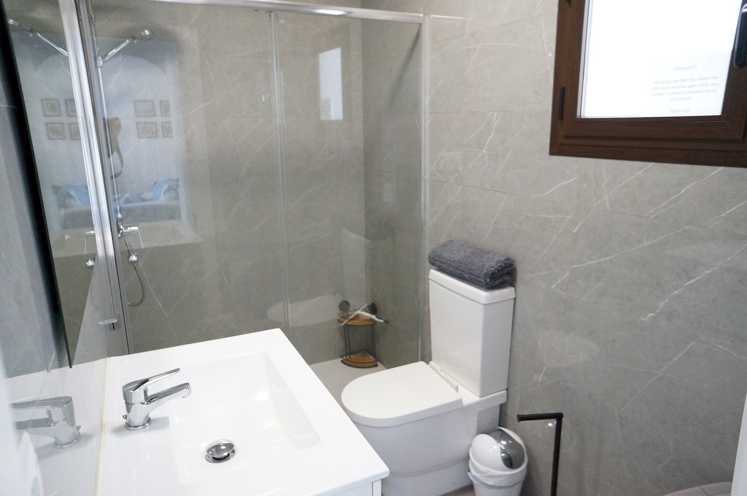 Une salle de bain avec douche, toilettes et lavabo.