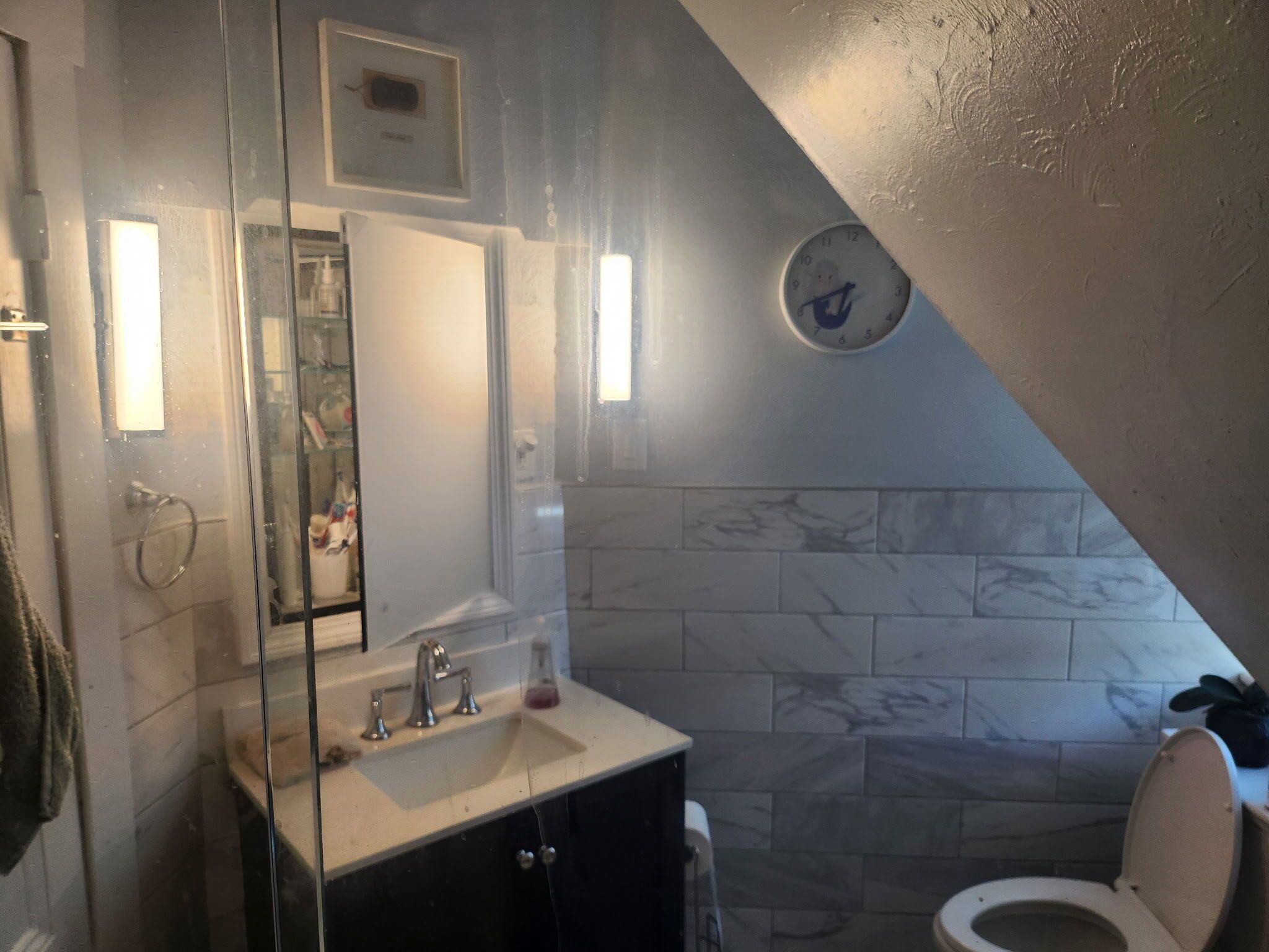 Ein Badezimmer mit Waschbecken, Spiegel und Toilette.