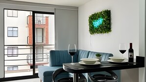 A modern living room with a sofa, a dining table, and a balcony view. - Apartamento en Pinares con piscina (Pereira)