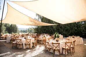 An outdoor event space with round tables, chairs, and a canopy. - Secluded Glamping Escape Surrounded by Forest and Valley Views in Sandpoint, Idaho (Sandpoint)