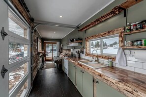 A compact kitchen with a central island, wooden cabinetry, and a view through the windows.