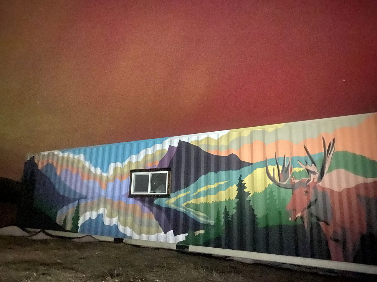 A mural with a mountain and deer on a wall.