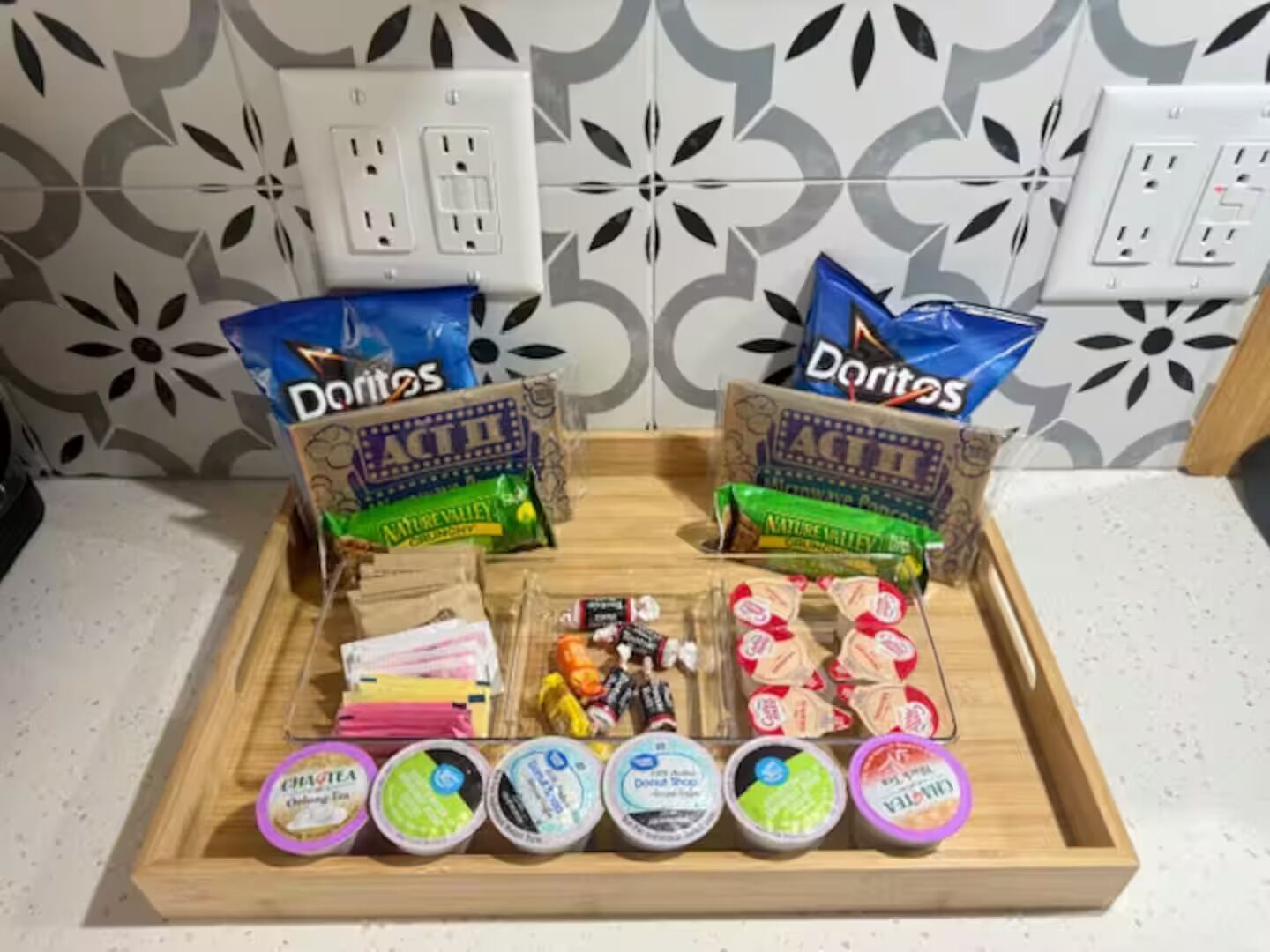 En bakke med snacks og yoghurtkopper på en køkkenbordplade.