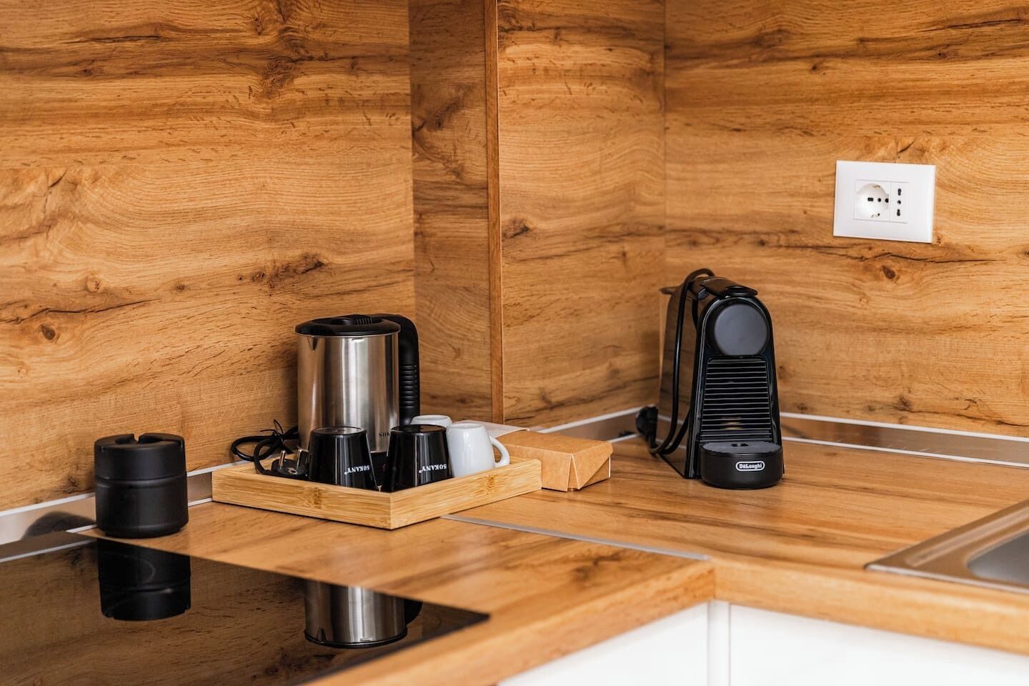 Eine Küche mit Holzsäulen, einer Kaffeemaschine, einem Wasserkocher und einem Toaster auf der Arbeitsfläche.
