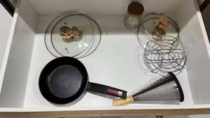 Eine Küche mit Herd, Pfanne und Reibe.
