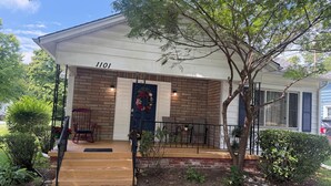 A house with a brick facade, a front porch with a wooden bench, and a mailbox marked '1101'. - Beautiful modern renovated 4 bedroom and 4.5 bath within a block of HPU (High Point)