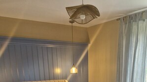 A bedroom with a large bed, a bedside table, a lamp, and a window with curtains. - Peaceful 2-bedroom house in DL perfect for relaxing getaways (DL)