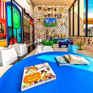 A children's play area with colorful furniture and a large TV screen. - LuxuryResort~MagicVillage~Ensuite Baths~NearDisney (Kissimmee)