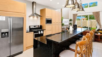 Una cocina moderna con una isla central, electrodomésticos de acero inoxidable y armarios de madera.