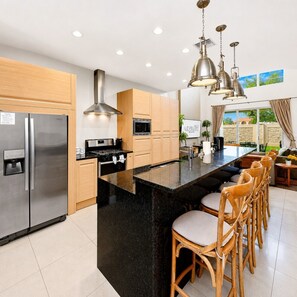 Una cocina moderna con una isla central, electrodomésticos de acero inoxidable y armarios de madera.